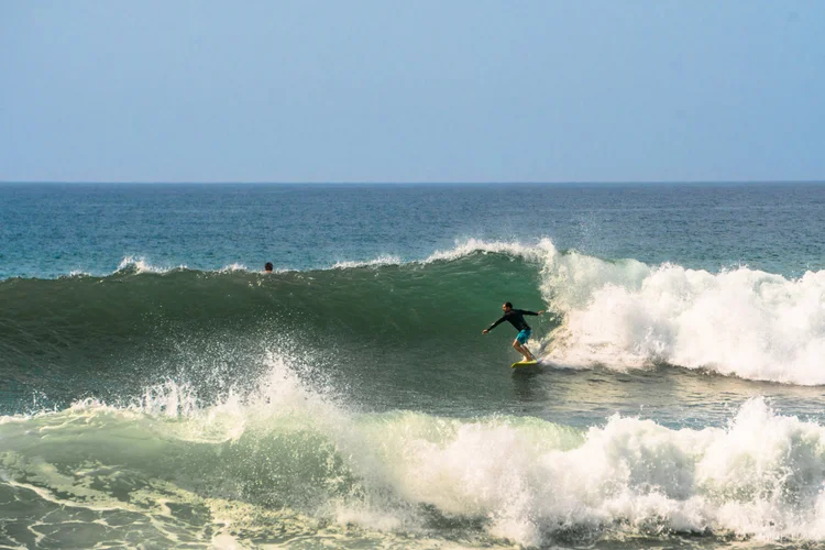 Surfer dropping into a clean wave